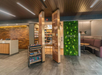 A small convenience store inside a hotel lobby with a wooden ceiling, snacks displayed on a cart, and a green wall with the word "CRATE" on it.