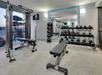 Fitness room with cardio equipment and weights.