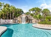 Outdoor pool with a waterfall and slide.