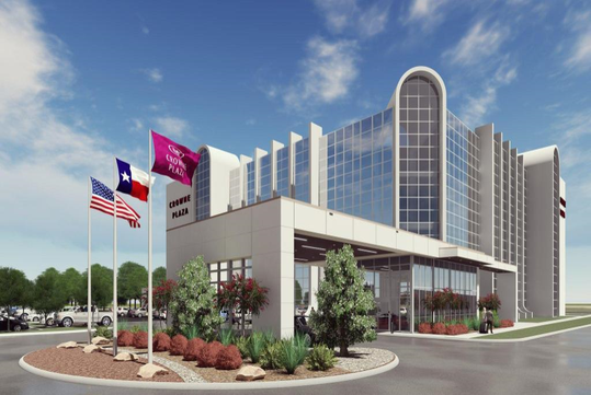 Modern hotel exterior with glass facade, surrounded by plants and flagpoles displaying the American, Texas, and hotel flags.