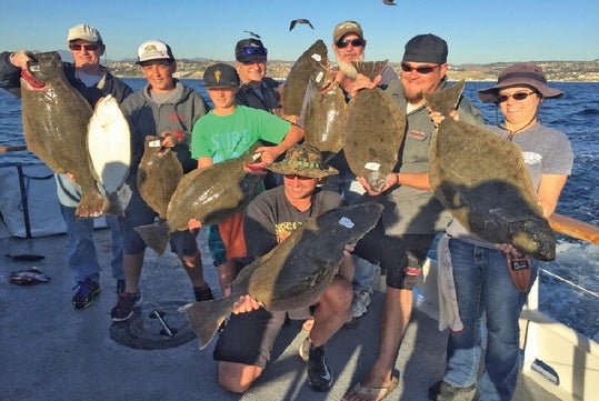 Anglers onboard the fishing boat proudly display their catch of the day.