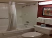 Shower/tub combo, toilet, and fresh towels in a guest bathroom.