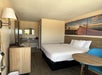 Guest room with one king bed, seating area, and flat-screen TV.