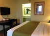One queen bed and a flat-screen TV inside a guest room.