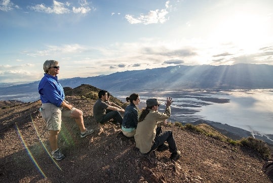 The tour group and guide watching the sun set over the mountains on the Death Valley - Pink Jeep Tour in Las Vegas, NV