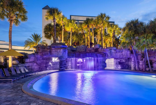 Relax in the serene outdoor pool area featuring a waterfall.