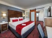 One king bed, flat screen TV, desk and chair in a separate bedroom
