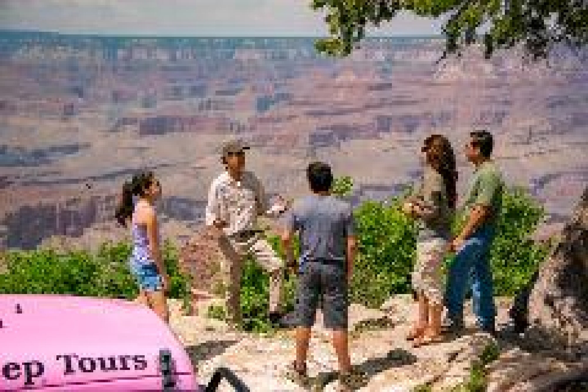 A guide speaks to four people near the edge of the Grand Canyon, with a pink Jeep marked "Jeep Tours" visible in the foreground.