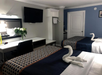 Two queen beds, a work desk, flat-screen TV inside a guest room.