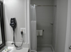 Fresh towels, shower and a blower inside a private bathroom.