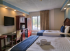 Double room with a desk and chair, flat-screen TV, microwave, and a mini fridge.