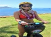 A girl on her segway in front of the ocean on the Diamond Head Segway Tour, Honolulu Hawaii.