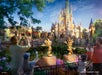 Artist's concept of a family standing in front of Mickey & Minnie 50th anniversary statues & Cinderella's Castle in the background at dusk.