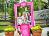A family posing in a pink photo frame at the entrance to Dollywood Theme Park in Pigeon Forge, TN
