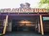 Entrance to the Blazing Fury ride at Dollywood, featuring a wooden building facade with a fire station theme and vintage fire equipment inside.