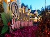 Colorful sign reads "Dollywood Smoky Mountain Christmas" surrounded by holiday decorations and lights.