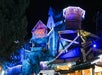 Nighttime theme park ride with a "Mystery Mine" sign, adorned with festive lights and decorations.