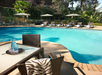 Outdoor pool with sub lounges and parasols.