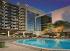Outdoor view of a DoubleTree Hotel with a lit swimming pool, surrounded by lounge chairs and palm trees, set against a dusky sky.
