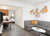 Seating area with a sofa bed and a flat-screen inside a guest room.