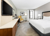 Guest room with one king bed, 50-inch HDTV, and work desk.