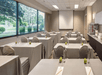 Meeting facility with tables, chairs and a projector screen.