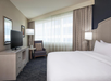One king bed, a chair, an expanded window and a flat-screen TV.