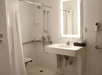 Accessible shower with grab bars inside a private bathroom.
