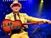 Comedian Jarret Dougherty with his famous guitar with written words "Clap Loud" as he cracks his goofy jokes to the audience.