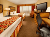 Two queen beds, a work desk, a flat-screen TV, and a sofa inside a non-smoking room.