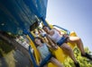 Several children, along with a mother holding her daughter, are delighting in a thrilling ride on the Merlin’s Mayhem suspension coaster on a beautiful day at Dutch Wonderland in Lancaster, Pennsylvania.