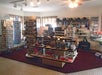 A small gift shop interior featuring various merchandise displays, including keychains, postcards, and souvenirs, arranged on stands and shelves.