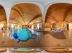 Panoramic view of an indoor pool with wooden ceiling, tiled floor, and several chairs and tables around the pool area.