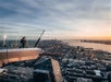 A woman enjoying the view off of the sky deck at sunset with the city in the distance at Edge New York.