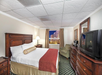 Guest room with one king bed, seating area, coffee maker, TV, and city view.