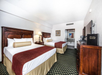 Guest room with two queen beds, flat-screen TV, and coffee maker.