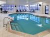 Refreshing indoor pool with poolside chairs.