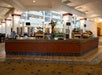 A breakfast buffet bar with several different food options in the lobby of the Embassy Suites by Hilton Portland Airport.