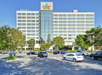 Hotel exterior with outdoor parking spaces.