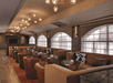 Modern lounge with brown leather seating, cow-print accent pillows, round tables, and contemporary light fixtures, set against large arched windows.