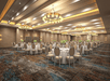 Meeting/Banquet facility with tables, chairs and carpeted floors.