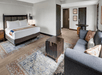 One king bed and a spacious seating area inside a guest room.