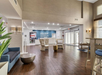 Hotel lobby with wooden floor, modern seating, and a welcome sign on the rear wall. Bright, natural light from large windows.