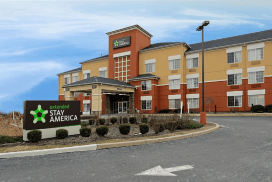 Exterior view of an Extended Stay America hotel with a large sign in the foreground.