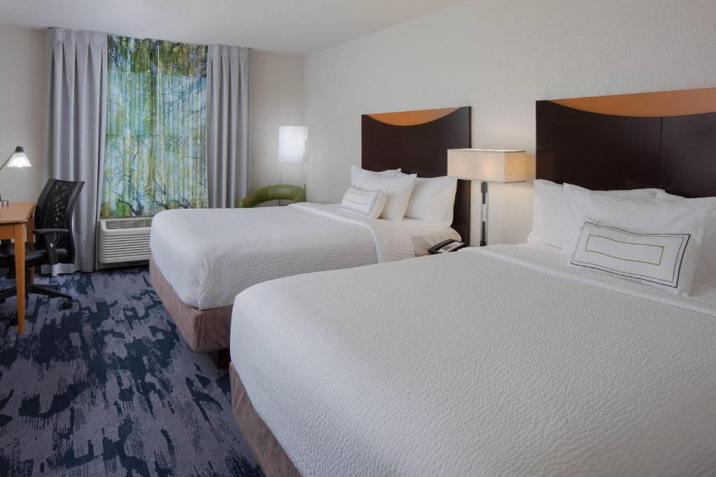 Guest room with two queen beds, work desk and chair.