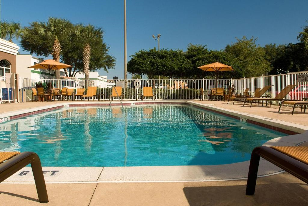 Outdoor pool with chairs and umbrellas.