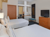 Two queen beds, a work desk, a coffee/tea machine, and a flat-screen TV inside a non-smoking room.