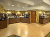 A full breakfast buffet with several different food choices with dark brown cabinets underneath at the Fairfield Inn & Suites Orlando.