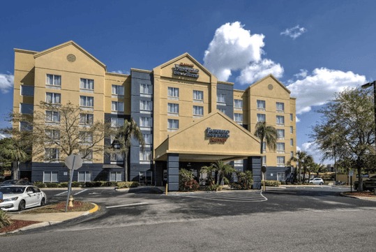 The front exterior of the Fairfield Inn & Suites by Marriott Near Universal Orlando on a sunny day in Orlando, FL