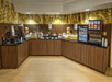 A breakfast buffet with several different food and drink options with brown cabinets underneath at the Fairfield Inn & Suites.